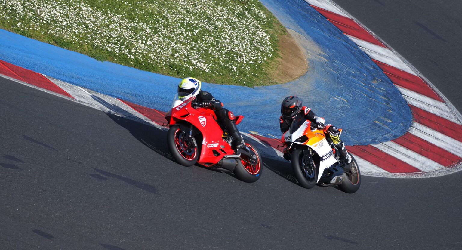 Two riders racing through a corner at a trackday